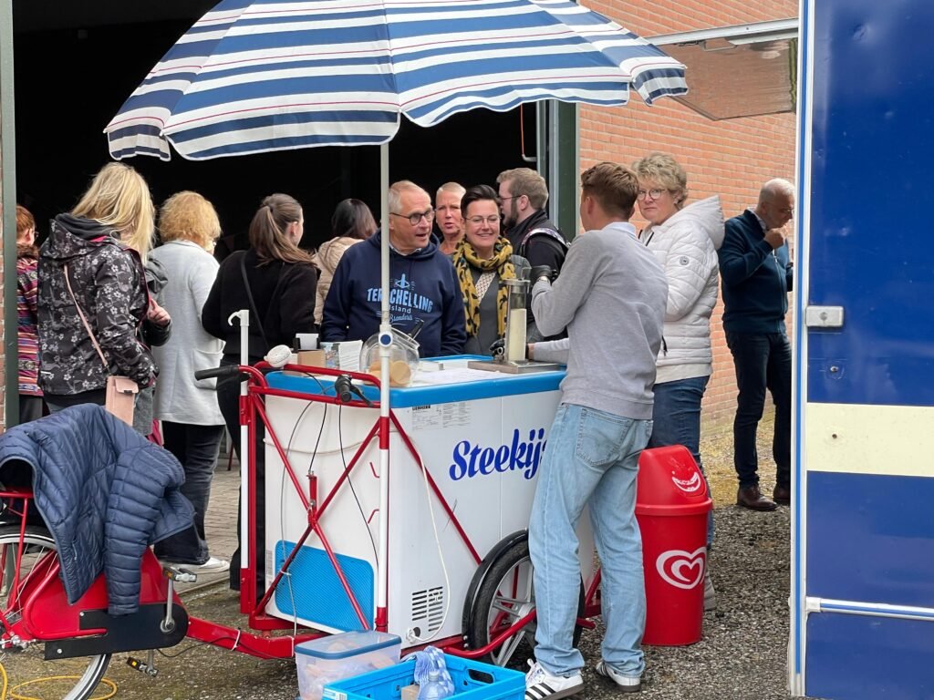 Gezellige drukte rondom een steekijs kar tijdens een evenement in Noord-Nederland